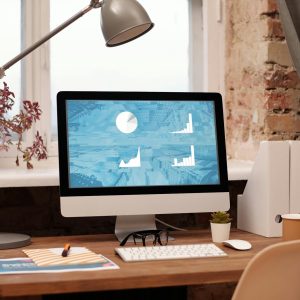 Clean and modern home office setup with computer, lamp, and decor. Ideal for productivity in a contemporary workspace.